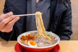 man-eating-noodles-in-soup-with-ramen-egg