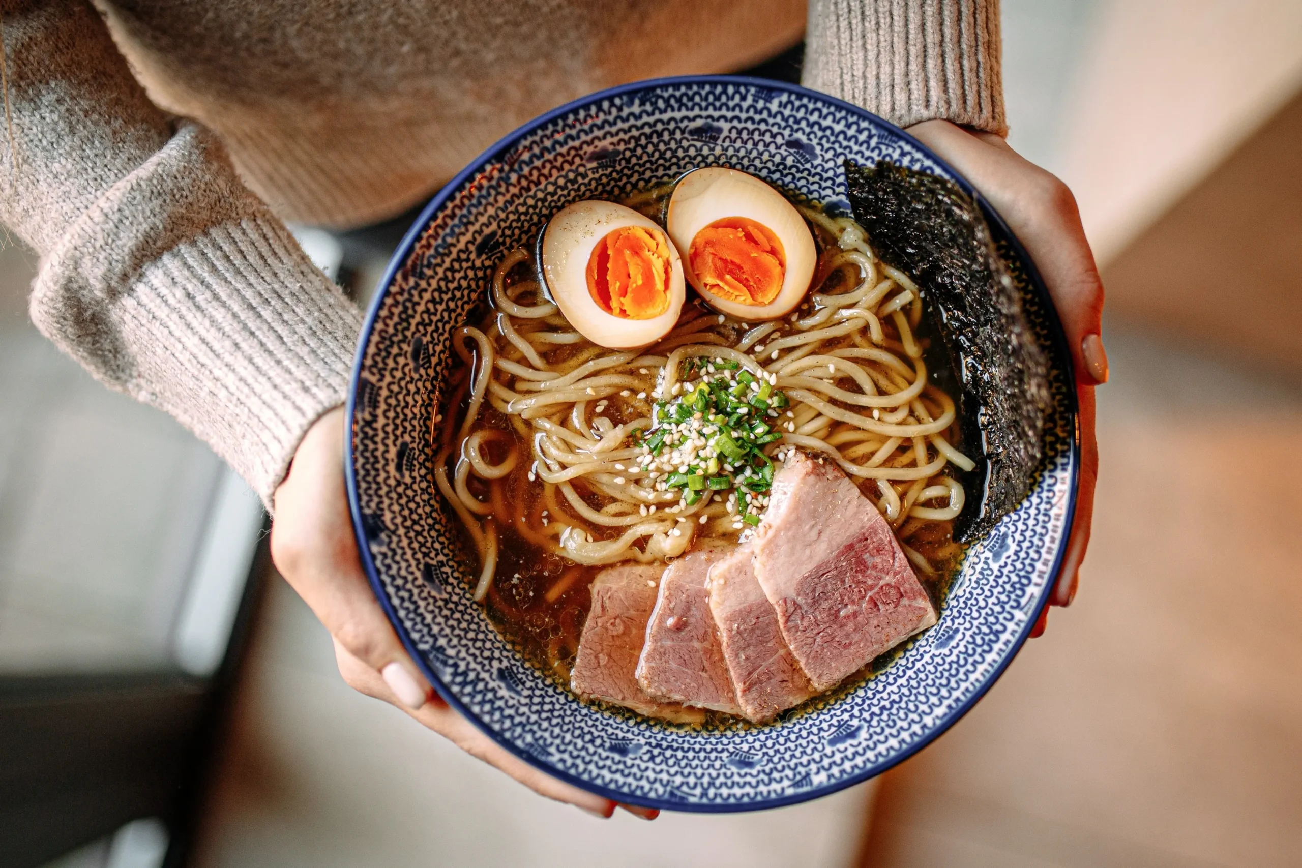 top-view-of-person-holding-a-ramen-bowl
